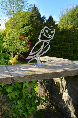 Photo of stainless steel Barn Owl sculpture in garden