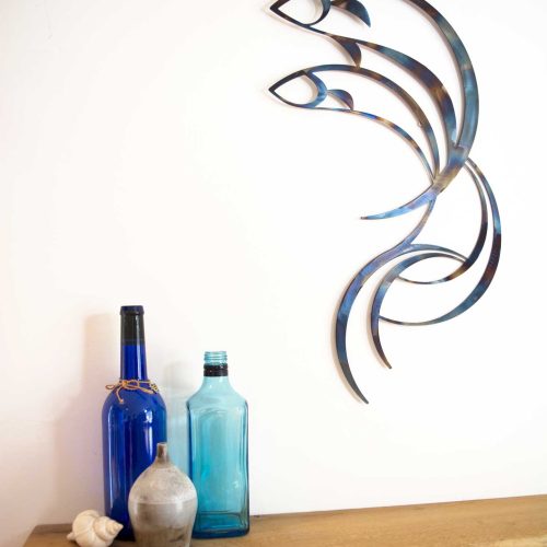 Photo of metal wall art featuring two fish leaping from a wave